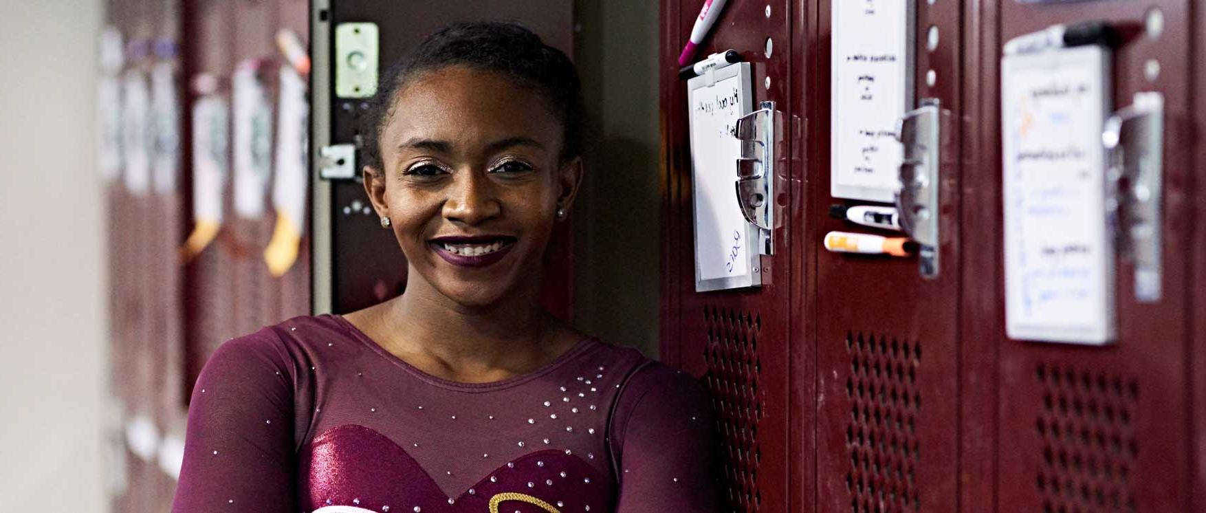 athlete poses next to locker